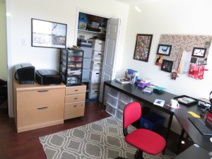 Home office with desk, chair, rug, filing cabinets and closet full of boxes